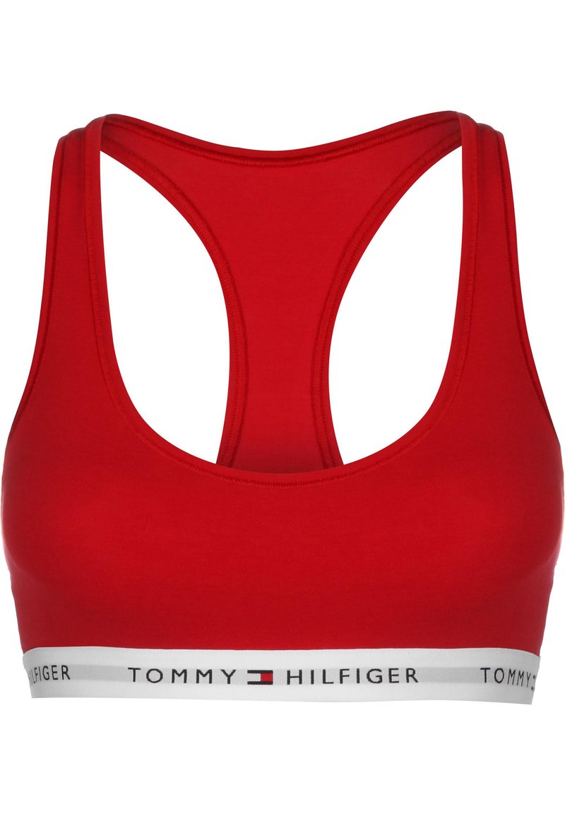Reggiseno sportivo rosso con design dietro a corsetto. Realizzato in tessuto elasticizzato, presenta una banda bianca con il testo e il logo "TOMMY HILFIGER".