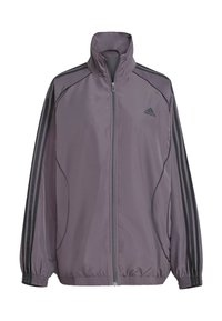 Vaaleanlila polyesteritakki, jossa on korkea kaulus, kokoontaitettava vetoketju, joustavat hihansuut ja kolme mustaa raitaa olkapäillä. Adidas-logo rinnassa.