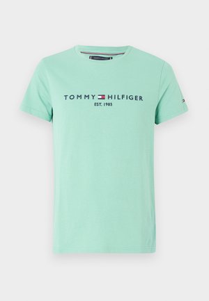 Camiseta de algodón en verde menta con mangas cortas y cuello redondo. Presenta "TOMMY HILFIGER EST. 1985" impreso en azul marino y blanco.