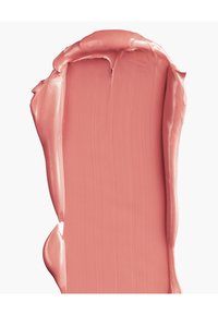 Échantillon de rouge à lèvres crémeux dans une teinte rose pâle, avec une texture lisse et brillante et un bord légèrement irrégulier, révélant des couches d'application.