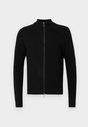 Czarny sweter na zamek z wysokim kołnierzem, prążkowanymi akcentami na ramionach i gładką teksturą materiału. Posiada dopasowane długie rękawy i prosty dół.