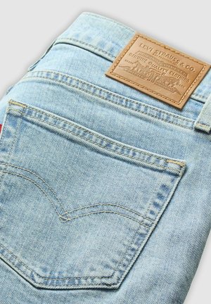 Jeans di denim blu chiaro con una patch in pelle del marchio, con cuciture curved sui taschini posteriori e un design standard della vita.