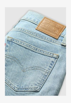 Jeans di denim blu chiaro con una patch in pelle del marchio, con cuciture curved sui taschini posteriori e un design standard della vita.