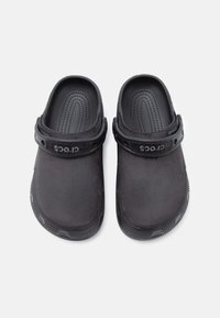 Pair of black Crocs clogs with adjustable heel straps and textured footbeds, displayed side by side on a white background.