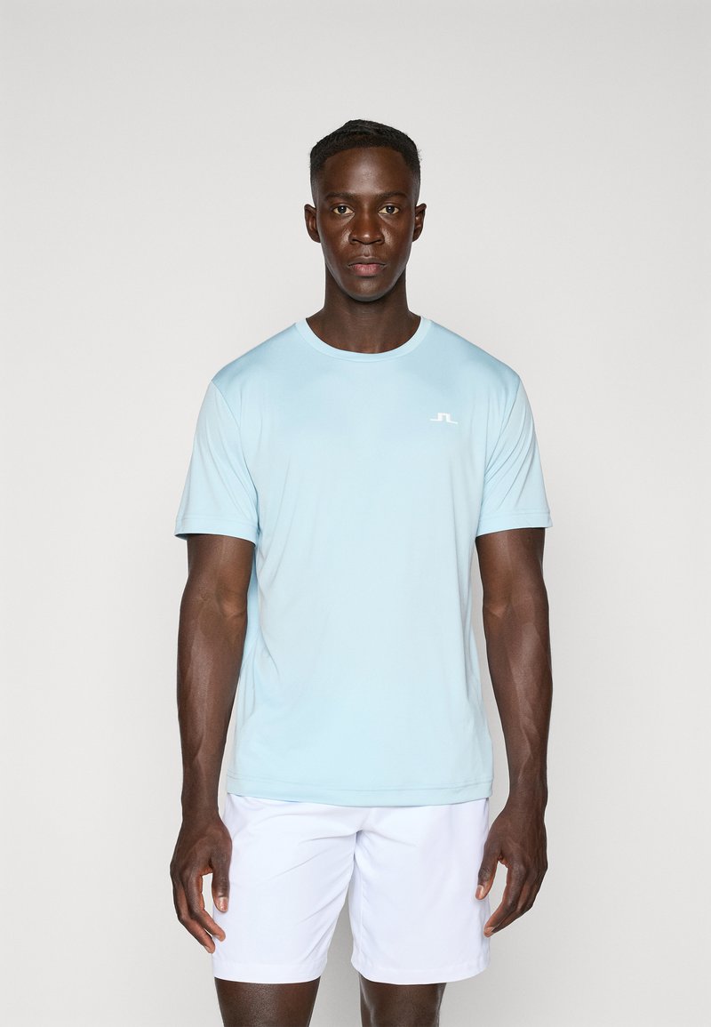 Light blue short-sleeve athletic t-shirt made from breathable material, featuring a round neckline and a small white logo on the left chest.