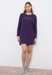 Fioletowa, długosleeve nocna sukienka z okrągłym dekoltem, z motywem kosmicznym w kolorze srebrnym na piersi, gładki materiał i luźny krój.