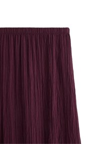 Bordeaux-farvet plisseret nederdel med elastisk talje. Stoffet har et tekstureret, krøllet design over hele overfladen.