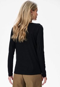 Zwarte long-sleeve top van zachte stof, met een eenvoudig ontwerp en een losse pasvorm, rond de hals en een rechte zoom.
