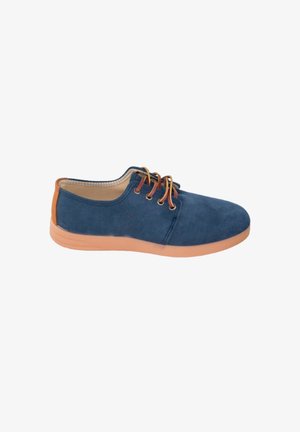 Zapato azul de ante con suela de goma marrón clara. Presenta cordones redondeados y un diseño suave y curvado con un acento beige en el tacón.