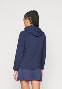 Navy blue lightweight jacket with a hood, featuring long sleeves, a slightly cinched waist, and smooth fabric texture.