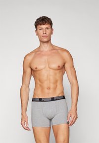 Gray boxer shorts with a black PUMA logo waistband. The material appears soft and stretchy, designed for comfort and fit.