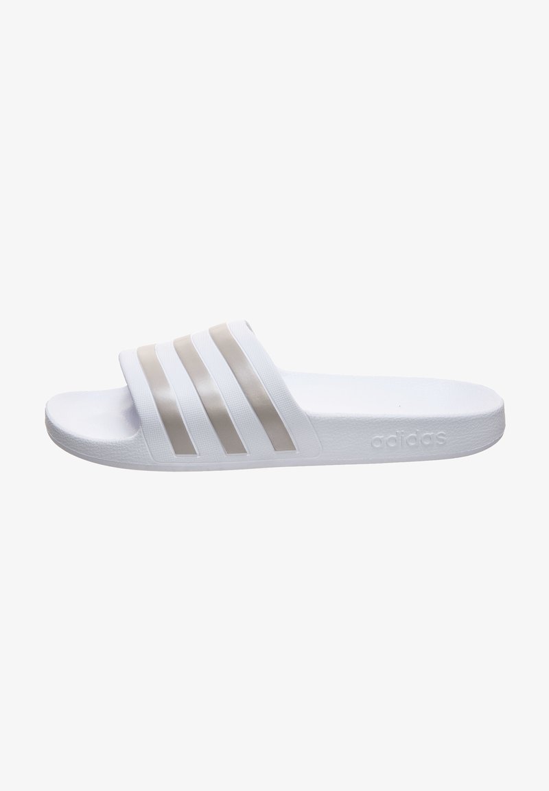 White slide sandal made of synthetic material, featuring three horizontal beige stripes on the upper, textured sole, and embossed logo on the side.