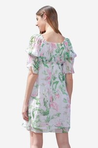 Robe d'été florale avec des manches bouffantes, présentant une base blanche, un imprimé floral rose et vert, et un col smocké pour le confort.