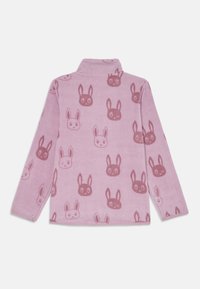 Fleece-pullover i myk rosa med et gjentatt kaninmønster i mørkere nyanser. Har kragehals og lange ermer.