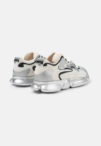 Sneaker con una toma superiore in rete bianca, dettagli argento, motivo grigio a onde e una suola in argento ammortizzata. Nome del marchio sul tallone.