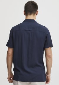 Korte mouwen, marineblauw shirt van gladde stof met een klassieke kraag en een detail op de rug, met een relaxte pasvorm en een minimalistisch design.
