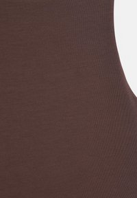 Tissu marron à texture lisse avec une légère élasticité, ajusté et courbé le long d'un bord de surface.