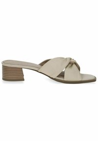 Beige open-toe mules with knotted soft leather straps and a low, textured block heel showcasing horizontal grooves.