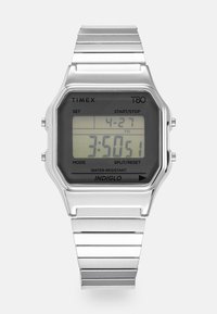 Timex T80 skaitmeninis laikrodis su stačiakampiu juodu LCD ekranu, sidabriniu nerūdijančio plieno korpusu ir apyranke, atsparus vandeniui, su INDIGLO apšvietimu.