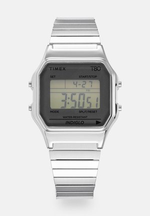 Montre numérique Timex T80 avec un écran LCD rectangulaire noir, boîtier et bracelet en acier inoxydable argenté, résistant à l'eau, avec rétroéclairage INDIGLO.