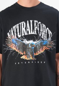 Sort bomulds t-shirt med et grafisk print af enørn med flammende accenter og teksten "NATURALFORCE" ovenfor og "NEVERSLEEP" nedenfor.