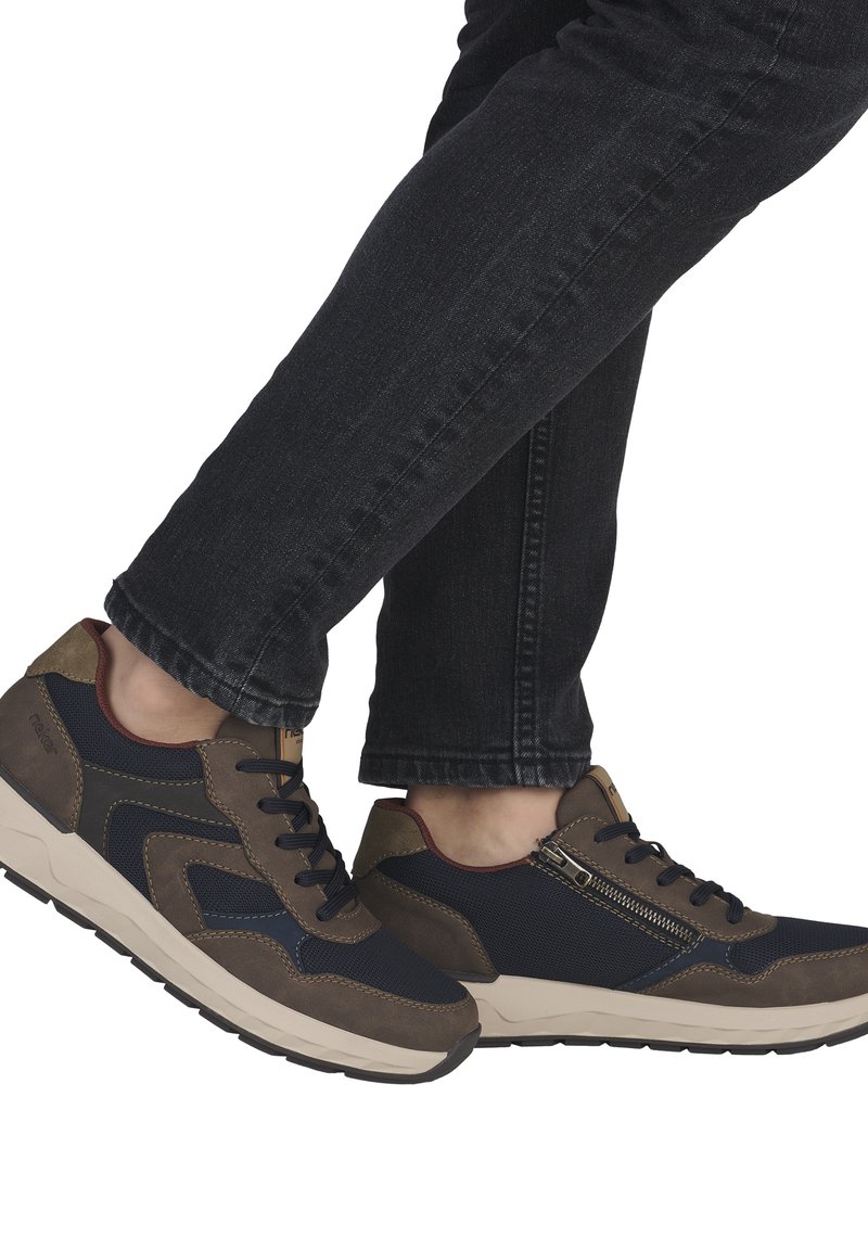 Baskets en mesh navy et daim marron, avec une fermeture éclair sur le côté, des lacets noirs et une semelle en caoutchouc beige.