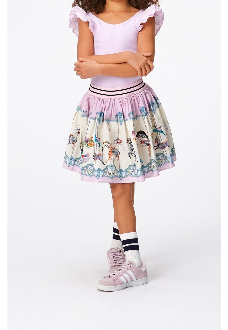 Haut à volants rose associé à une jupe mi-longue ornée d'un motif d'animaux de carrousel fantaisiste et d'une ceinture à rayures noires.