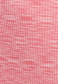 Textúrovaná látka v svetloružovej farbe s bielymi vertikálnymi pruhmi a kockovaným vzorom, prezentujúca jemný, tkaný vzhľad.