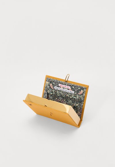 Yellow clutch purse with a gold clasp, featuring a colorful floral interior lining and a label reading "Handmade with love in Italy."