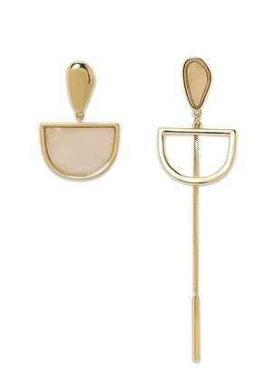 Goldene Tropf-Ohrstecker mit einem halbkreisförmigen weißen Stein, der eine glatte, glänzende Oberfläche und verlängerte goldene Akzente in einem minimalistischen Design aufweist.