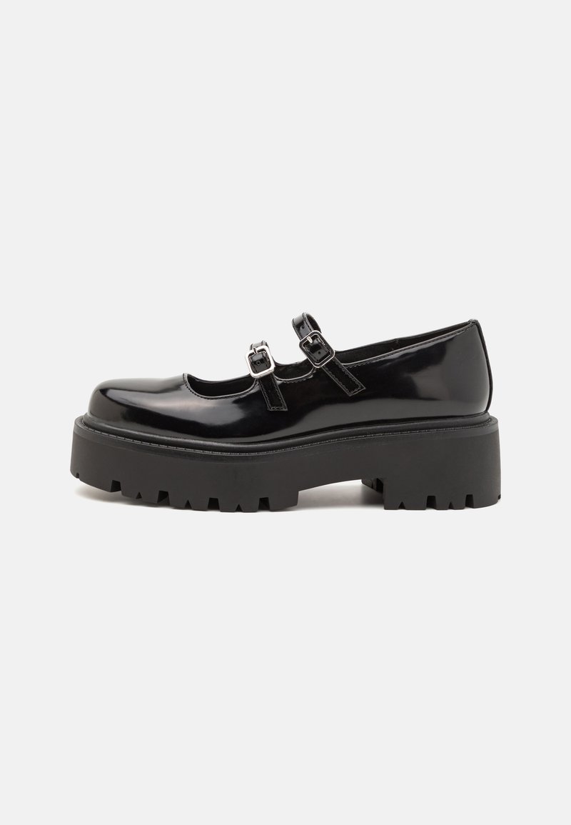 Black patent leather Mary Jane shoes with double straps, silver hardware, and a chunky, ridged platform sole. Smooth finish and rounded toe.