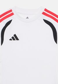 Λευκό αθλητικό πουκάμισο με κόκκινες και μαύρες ρίγες στους ώμους, με κεντημένο μαύρο λογότυπο Adidas στο μπροστινό μέρος.