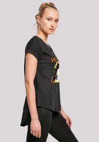 Black T-shirt with a loose fit, short sleeves, and a graphic design featuring geometric shapes and bold colors on the front.