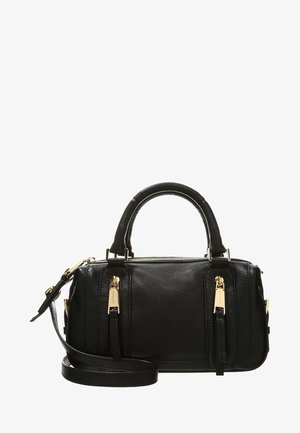 Sac à main en cuir noir avec deux poignées, détails de fermeture éclair dorés et une bandoulière réglable, posé sur un fond blanc.
