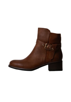 Bottine en cuir marron avec petit talon bloc et bride décorative avec boucle dorée sur le côté.