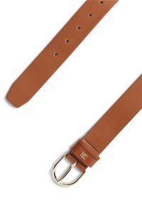 Ζώνη από δέρμα ταμπά με ομαλή υφή, αγκράφα σε χρυσό τόνο και διακοσμητικό λογότυπο. Ρυθμιζόμενη με πολλαπλές τρύπες για το μέγεθος.