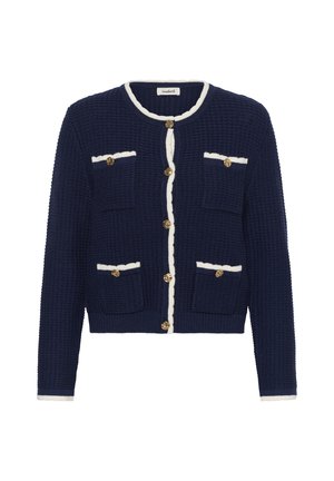 Tengerészkék kötött kardigán fehér szegéllyel, arany gombokkal és négy első zsebbel, fehér háttéren bemutatva.