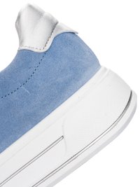 Nahaufnahme eines blauen Wildleder-Sneaker-Heels mit weißem gepolstertem Kragen und dicker weißer Gummisohle.