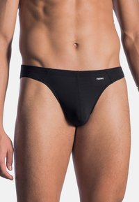 Male torso wearing black brief-style underwear against a plain white background.