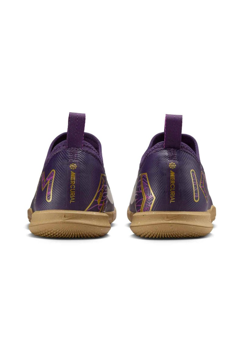 Zapatillas deportivas moradas con una parte superior texturizada, con acentos amarillos y una suela de goma. Incluyen una lengüeta en el talón para facilitar el calzado.