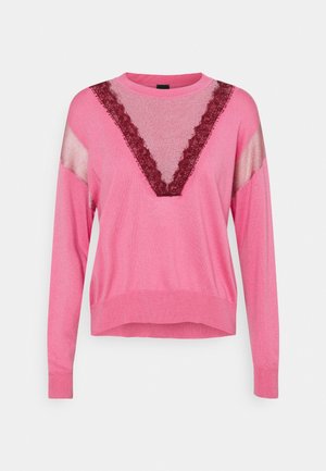 Pull rose à manches longues avec des panneaux transparents roses sur les épaules et une insertion en forme de V transparente borde de dentelle bordeaux sur la poitrine.