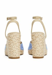 Sandali wedge in tela blu con cinturini alla caviglia beige e tacchi in iuta intrecciata. La finitura testurizzata sul tacco aggiunge dettagli.