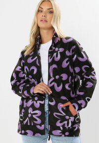 Czarna polarowa kurtka z fioletowym wzorem kwiatowym, na pełny zamek, z wysokim kołnierzem i dwiema przednimi kieszeniami. Miękka faktura i luźny krój.
