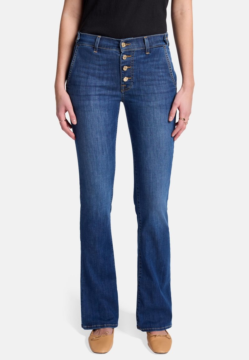 Jeans a zampa d'elefante in denim blu a vita alta, con patta di bottoni, cinque tasche e finitura lavaggio medio. Texture liscia con leggero elasticità.