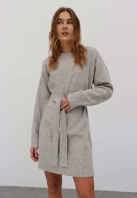 Graues gestricktes Kleid mit rundem Halsausschnitt, langen Ärmeln, tailliertem Bereich und geripptem Saum; weiche Textur mit glatter Oberfläche.