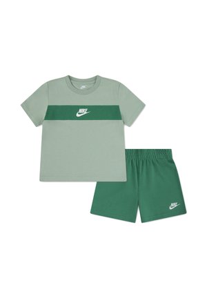 T-shirt à manches courtes Nike vert clair avec une bande horizontale vert foncé et un short assorti vert foncé, les deux présentant des logos Nike blancs.