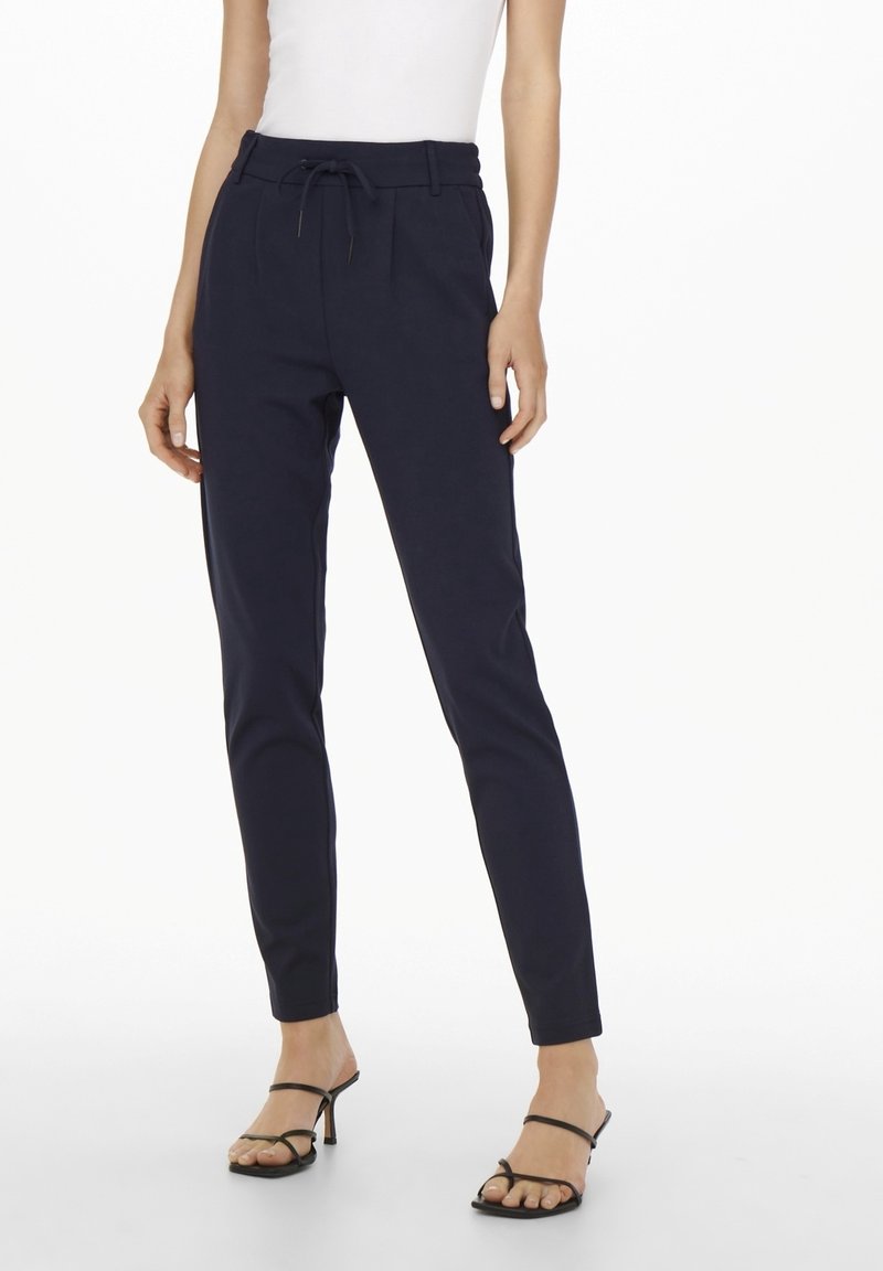 Navy blue tapered pants with a drawstring waist, crafted from soft fabric, featuring side pockets and a smooth texture.