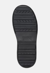Semelle de sandale en caoutchouc noir avec des motifs de crampons horizontaux et diagonaux, featuring le nom de la marque et la taille en relief. Texture lisse avec une forme contour.