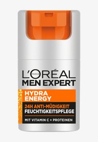 Silver bottle with a matte finish, orange plastic pump cap, black text label. Contains "Hydra Energy" and skincare benefits with Vitamin C.