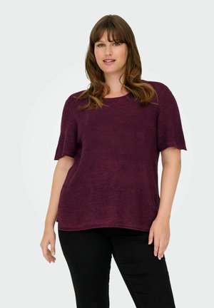Pull en tricot bordeaux à manches courtes avec un col rond et une coupe décontractée, doté d'une finition texturée et d'un ourlet droit. Pantalon noir porté.